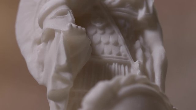 Closeup on a white marble statue of the Greek god Ares. Panning from down to high.