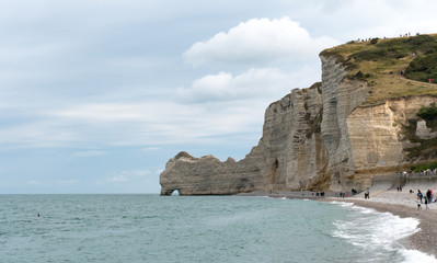 Fototapeta na wymiar many tourists enjoy a day at the rocky beaches and cliffs of the Normandy coast
