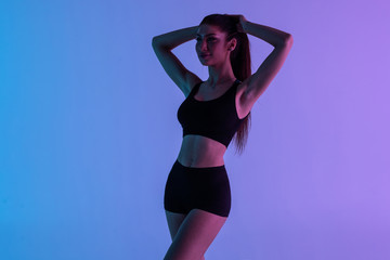 Obraz premium Full body of young cheerful smiling woman in sports wear, isolated over violet light background