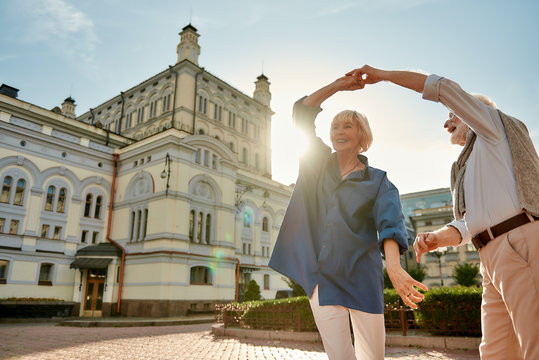 It's always fun just spending time with you. Beautiful and happy senior couple dancing together outdoors on a sunny day