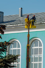 Repair of the gutter on the roof of the building. Using a telescopic car lift