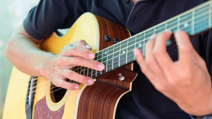 Fototapeta na wymiar Guitarist playing the Harmonic tapping technic with acoustic guitar