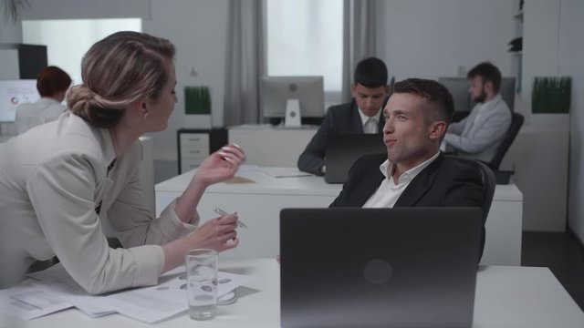 Collegues flirt and talk with each other at work.