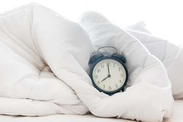 Alarm clock on bed early and wake up in morning  sunny day.