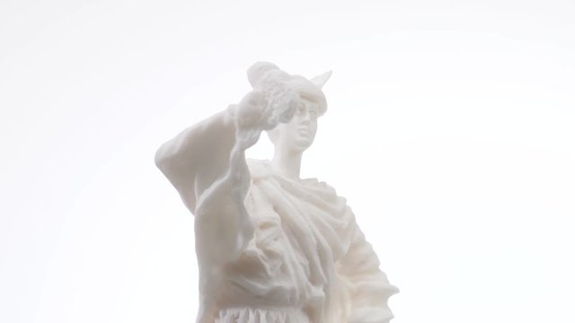 Old greek white marble statue rotating against a white background. Closeup shot. Hermes was god of trade, thieves, travelers, sports, athletes, and border crossings, guide to the Underworld.
