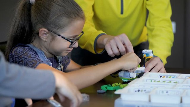 Kids creating robots with teacher. Early development, innovation, modern technology concept