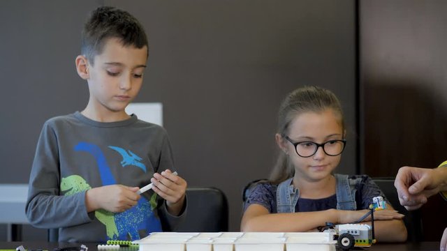 Kids creating robots with teacher. Early development, innovation, modern technology concept
