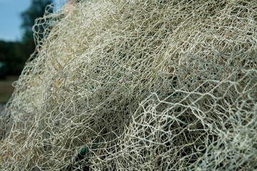 A mesh of white and orange fishing net in the summer sun.