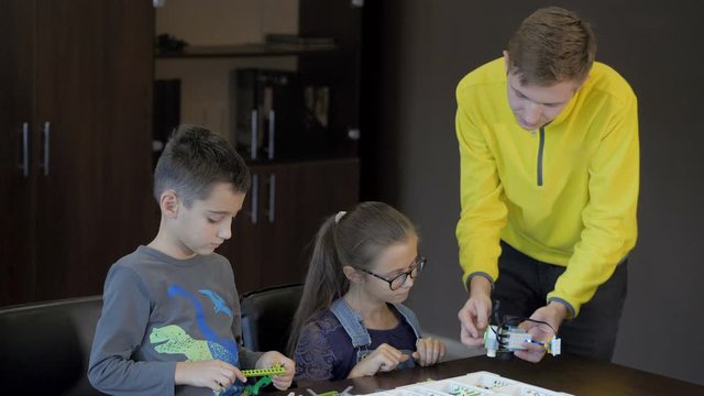 Kids creating robots with teacher. Early development, innovation, modern technology concept
