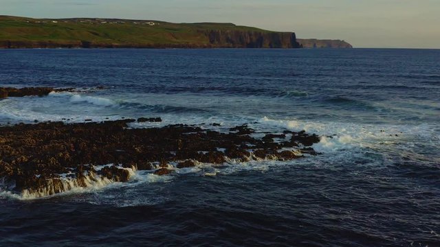 Aerial of waves hitting the rocky coastline near Cliffs of Moher, Ireland
