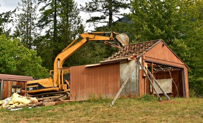 Excavator pulling roof apart house demo