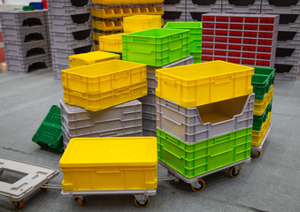 Stack of colorful empty plastic crate on trolley