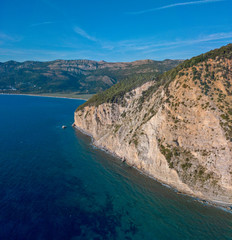 Aerial view of Buljarica promontory, steep cliff on the coast lapped by crystal clear waters of the Adriatic sea. Petrovac, coastal town in Budva municipality. Montenegro