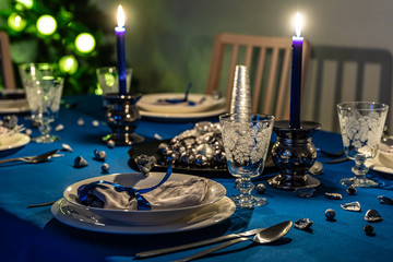 Christmas table setting with christmas tree in background
