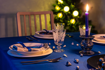 Christmas table setting with christmas tree in background