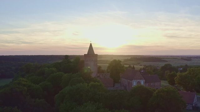 Flyover Aerial Shot of Castle in front of sunset in Germany Mecklenburg Vorpommern - Burg Stargard