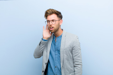 young businessman looking serious and curious, listening, trying to hear a secret conversation or...