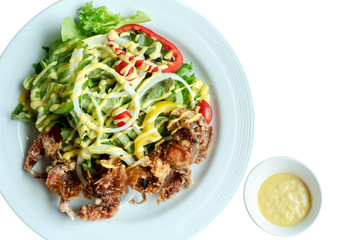 Soft shell crab salad with salad dressing on isolated whiet background. Top view.