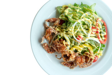 Soft shell crab salad with salad dressing on isolated whiet background. Top view.