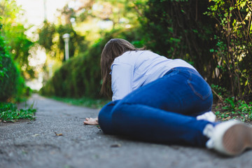 Fainting woman lying down while having heart pain outdoors