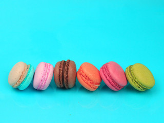 Colorful french macarons (macaroons) cake,  delicious sweet dessert on blue background with copyspace, food background concept.