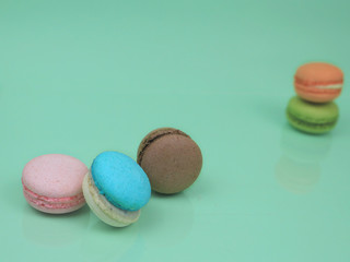 Colorful french macarons (macaroons) cake,  delicious sweet dessert on green background with copyspace, food background concept.