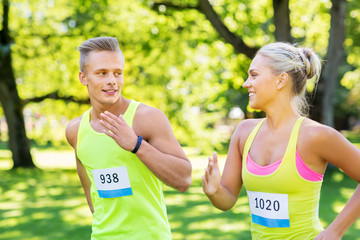 fitness, sport, race and healthy lifestyle concept - happy couple of sportsmen running marathon...