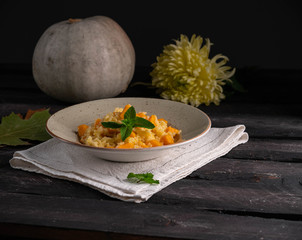 risotto with pumpkin, mint leaf top, pumpkin of the background