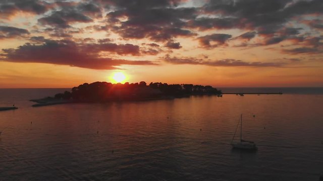 Aerial reveal shot island with sea, ocean at sunset, beautiful golden light, 4K.