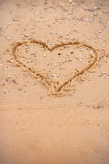 Heart on the beach. Draw a heart with your finger. Heart in the sand. Romantic photo concept. Valentine's Day, beach vacation. Photo background with hearts on the beach.