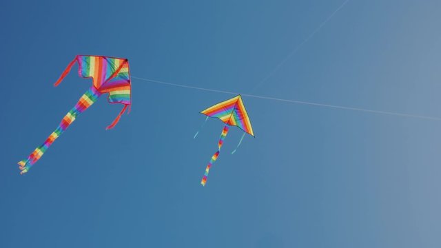 Two kites soar nearby high in the sky. Synchronization and precise control concept