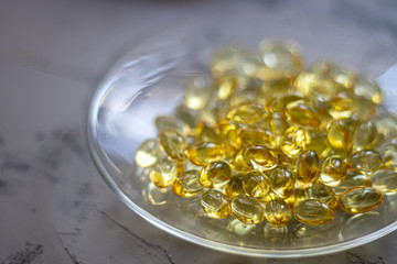 On a transparent plate are capsules filled with vitamin D. This is good for health. The sun's rays shine through them