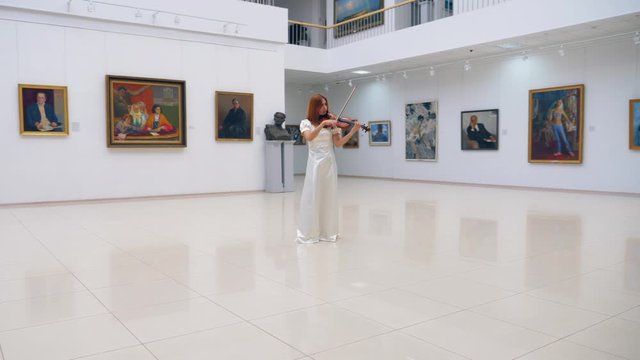 Gallery hall with a lady violinist playing the instrument