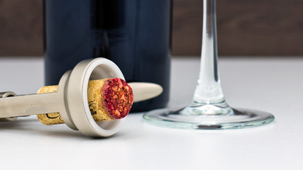 wine cork on a corkscrew from an uncorked bottle of red wine and a glass