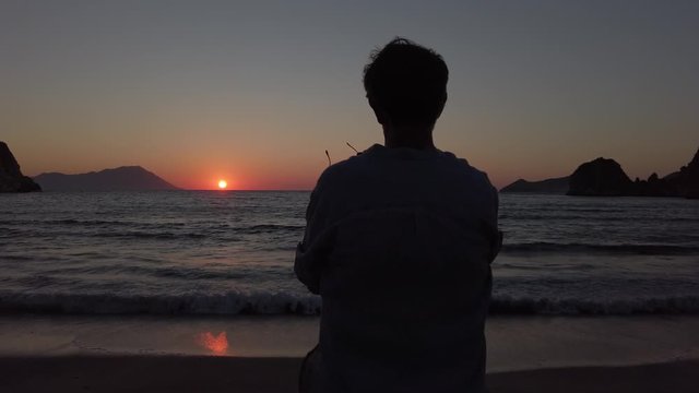 Sunset at Plathiena, Milos, Greece. Man Holding In His Hand A DJI Osmo Pocket Gimbal Camera