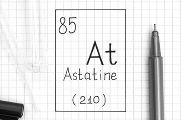 The Periodic table of elements. Handwriting chemical element Astatine At with black pen, test tube and pipette.