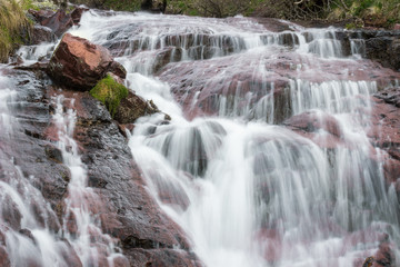 Close up details of scenic, colorful, powerful Monk's jump waterfall on Old mountain, the tallest in Serbia, streaming down the red, rocky cliff