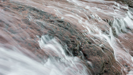 Close up details of scenic, colorful, powerful Monk's jump waterfall on Old mountain, the tallest in Serbia, streaming down the red, rocky cliff