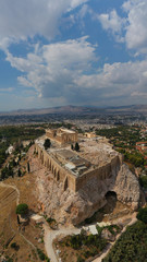 Aerial photo of unique Masterpiece of Ancient times the Parthenon on top of iconic Acropolis hill with beautiful clouds and blue sky, Athens, Attica, Greece