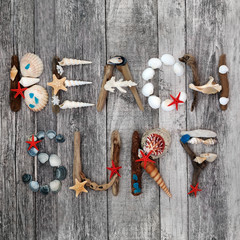 Abstract of driftwood, seashells, blue cobalt sea glass and pebbles forming the word beach surf on...