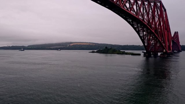 Low drone fly under the famous Forth Bridge rail bridge near Edinburgh Scotland
