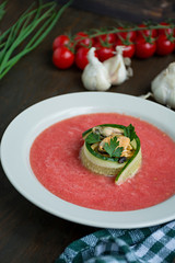 Traditional spanish cold gazpacho soup with mussels. Wooden background.