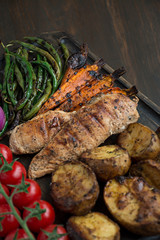 Grilled vegetables on a cutting board on a dark wooden background. Dark wooden background.