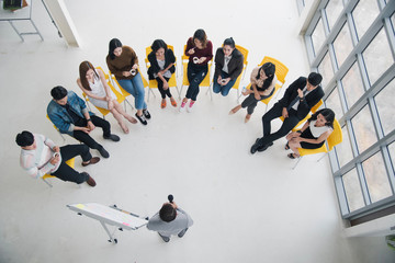 Seminar group, Successful young Asian business man and woman, the man speaker presenting to employees, business coach giving presentation to clients in meeting room, team leader reporting about work.