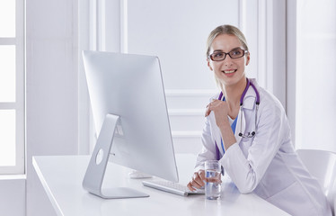 Portrait of a happy smiling young doctor in headset in office