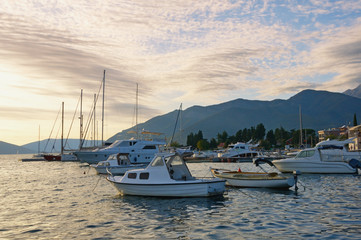 Fototapeta premium Beautiful evening Mediterranean landscape with fishing boats on water. Montenegro, Adriatic Sea, view of Bay of Kotor near Tivat city in autumn