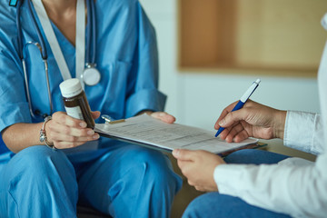 Beautiful smiling woman the doctor in a bottle of pill offers t
