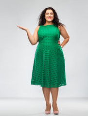 people and portrait concept - happy woman in red dress holding something on empty hand palm over grey background