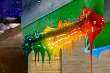 several dripping colors ink on handle printers in tee shirt factory hang on the storage
