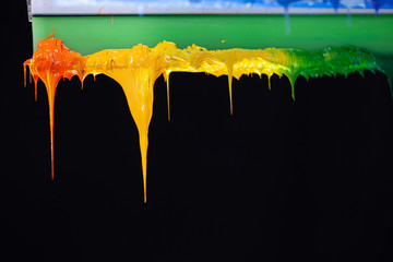 several dripping colors ink on handle printers in tee shirt factory hang on the storage - obrazy, fototapety, plakaty
